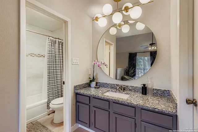 a bathroom with a granite countertop sink a toilet and a mirror