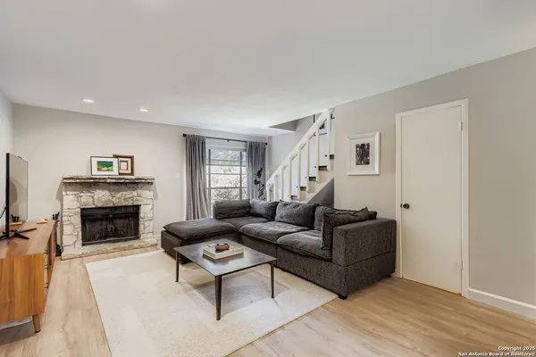 a living room with furniture a fireplace and a flat screen tv