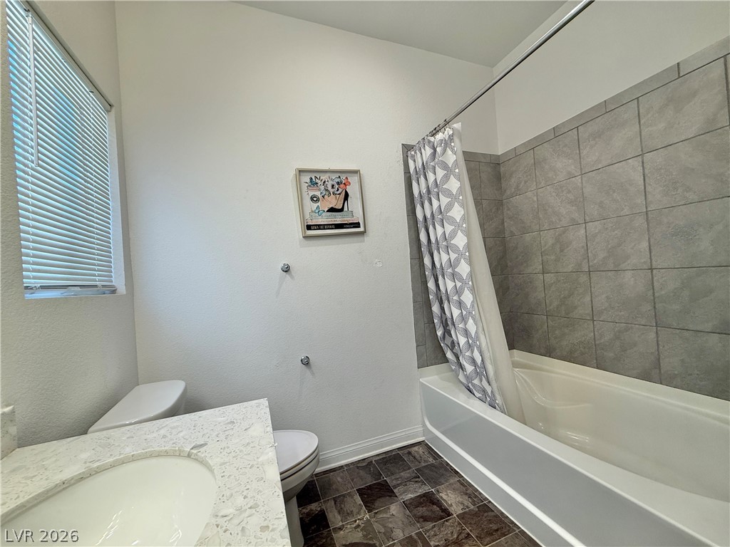 7777 South Westwind Road Las Vegas, NV 89139 - Photo 17 of 46 A well-appointed bath features a sleek vanity, convenient toilet, and a tiled shower-tub combination.