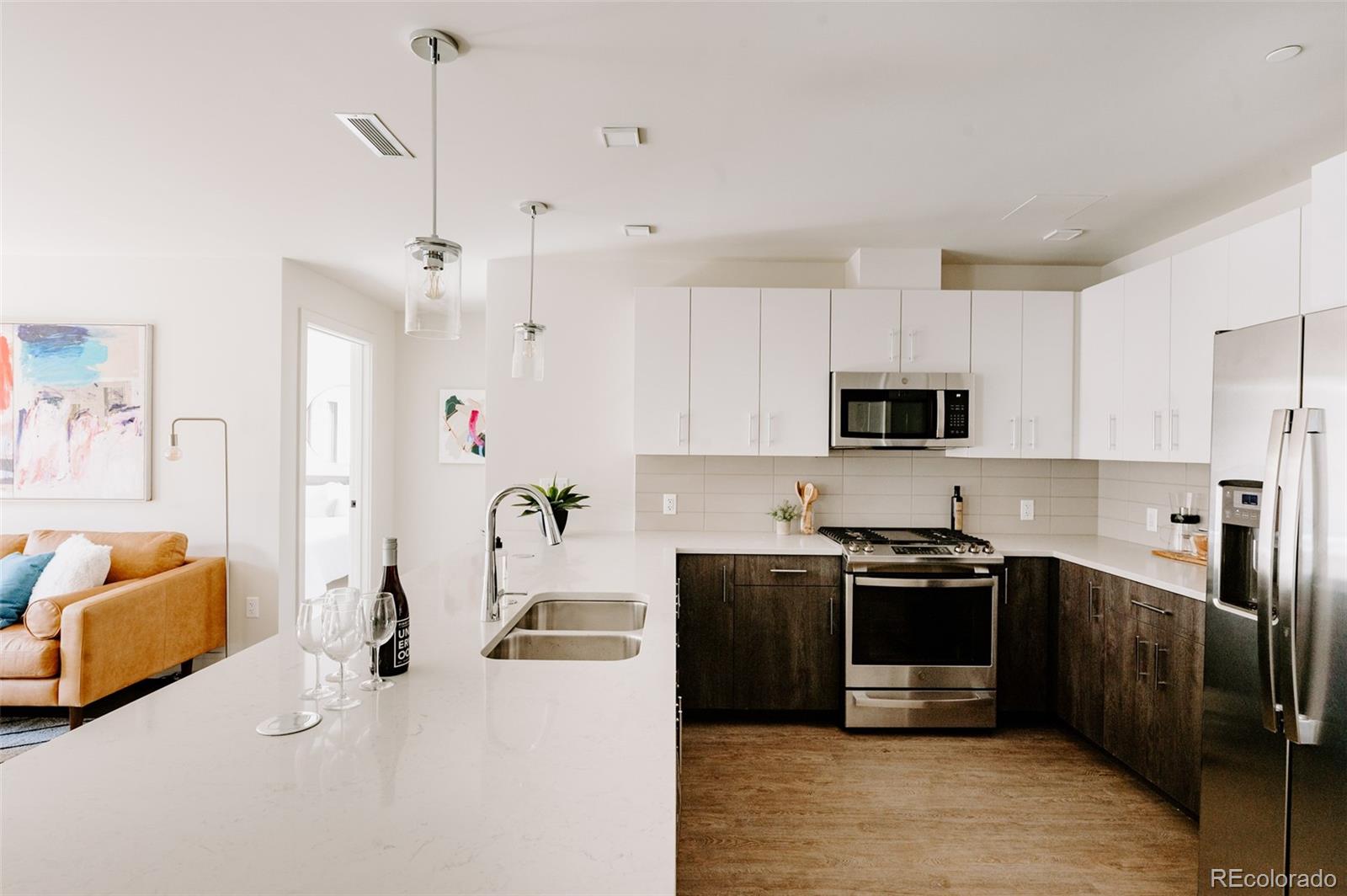 a kitchen with stainless steel appliances kitchen island granite countertop a sink a stove and a refrigerator