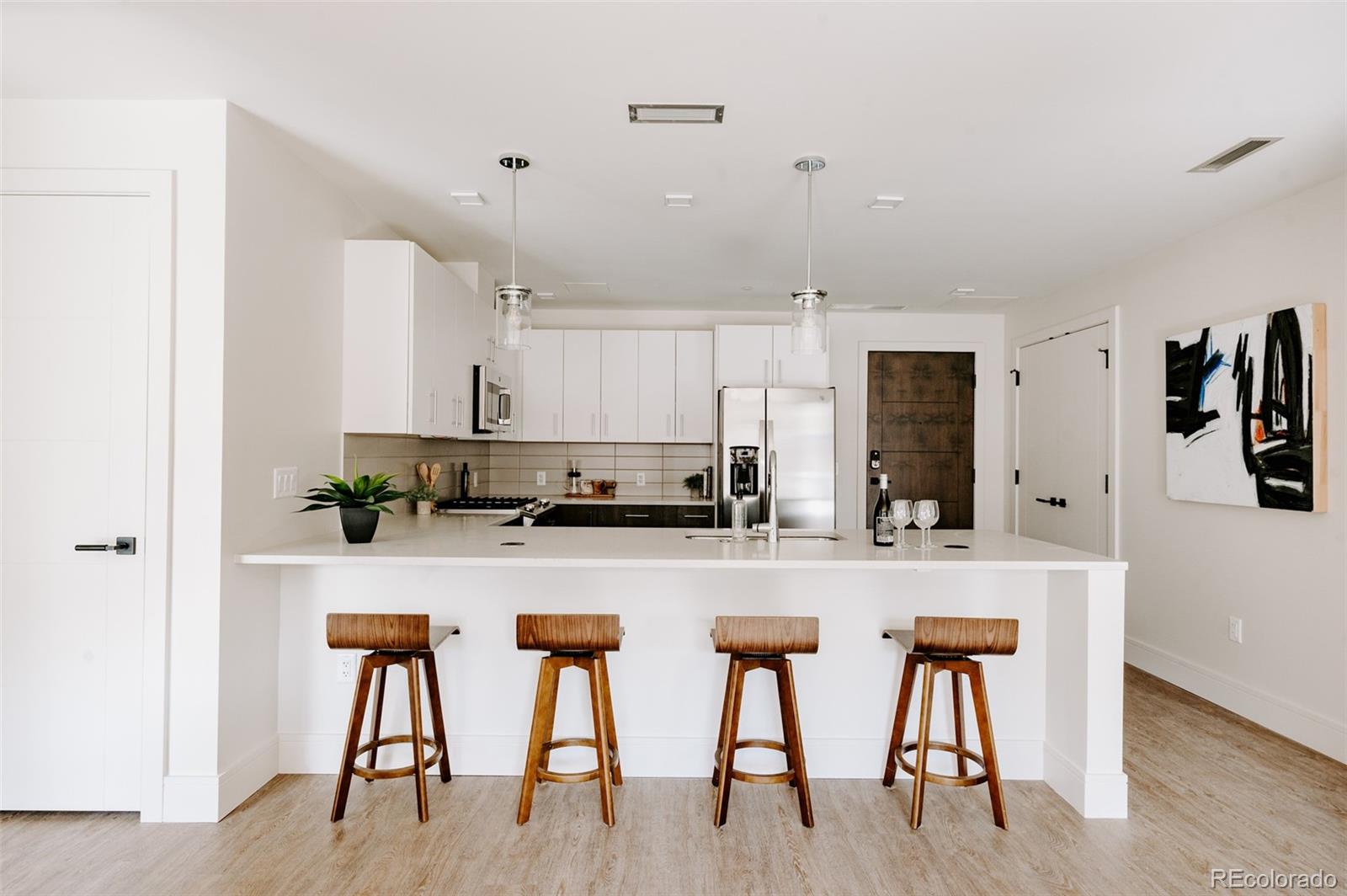 430 South Frontage Road East, Unit RUF Vail, CO 81657 - Photo 2 of 19 a kitchen with stainless steel appliances granite countertop a table chairs refrigerator and microwave