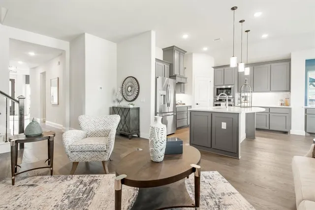 a living room with kitchen island furniture and a view of kitchen
