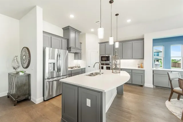 a kitchen with refrigerator a sink and chairs
