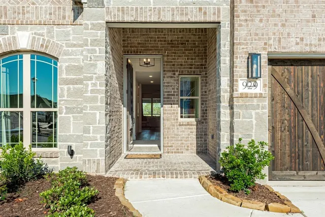 a view of a brick house with potted plants