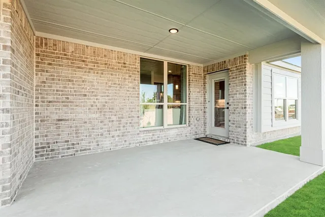 a view of an empty room with a fireplace and a window