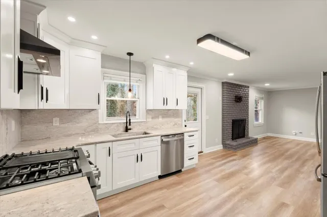 a large kitchen with stainless steel appliances kitchen island granite countertop a sink and cabinets