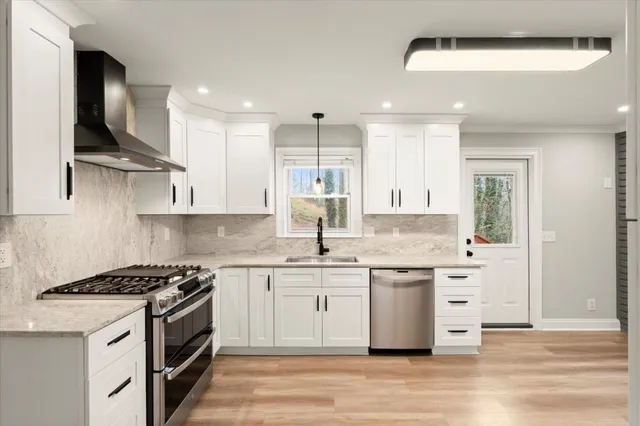 a kitchen with stainless steel appliances granite countertop a sink stove and refrigerator