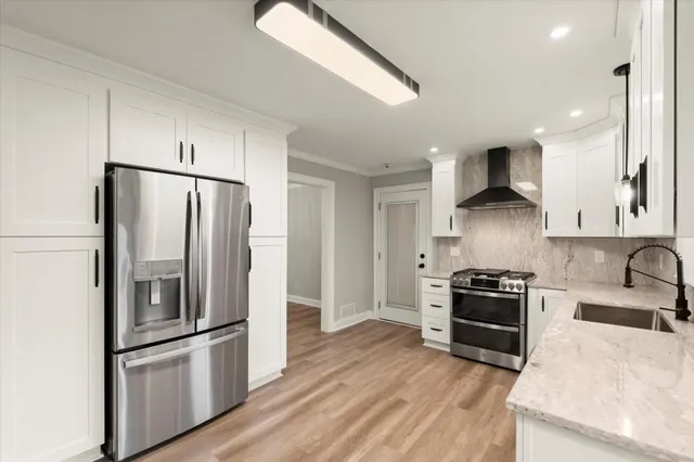a kitchen with stainless steel appliances granite countertop a refrigerator stove and sink