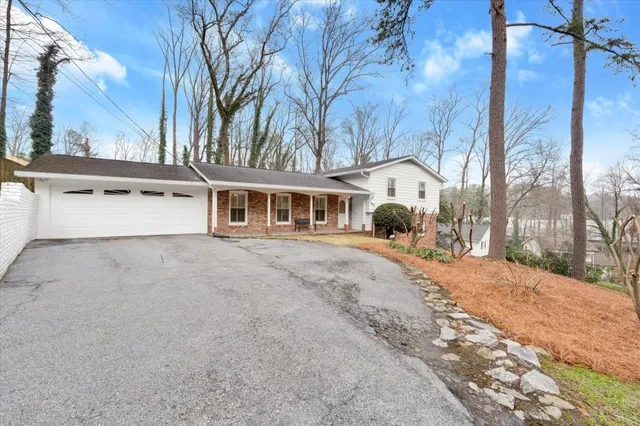 a view of a white house with a large tree