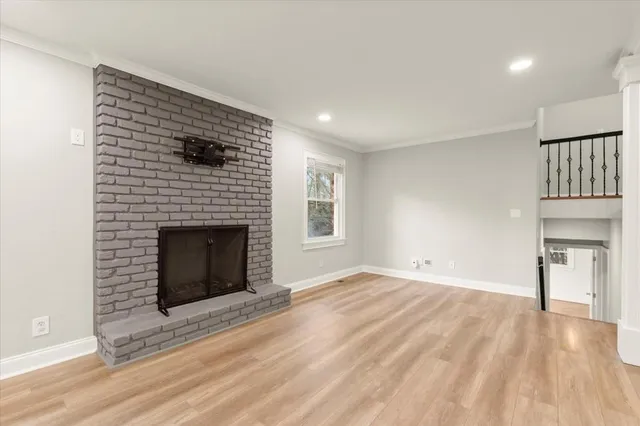 a view of an empty room with a fireplace and a window