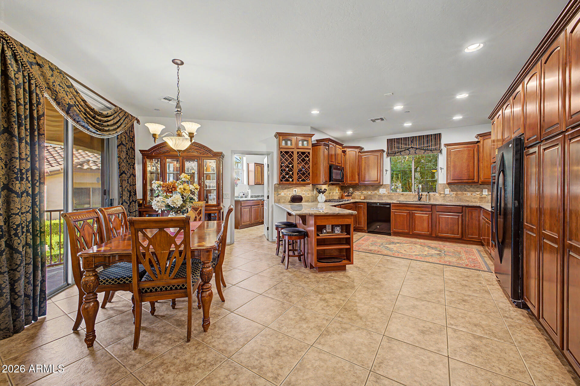 2996 East Agritopia Loop North Gilbert, AZ 85296 - Photo 10 of 73 a kitchen with stainless steel appliances kitchen island granite countertop a refrigerator a stove a sink and a dining table with wooden floor
