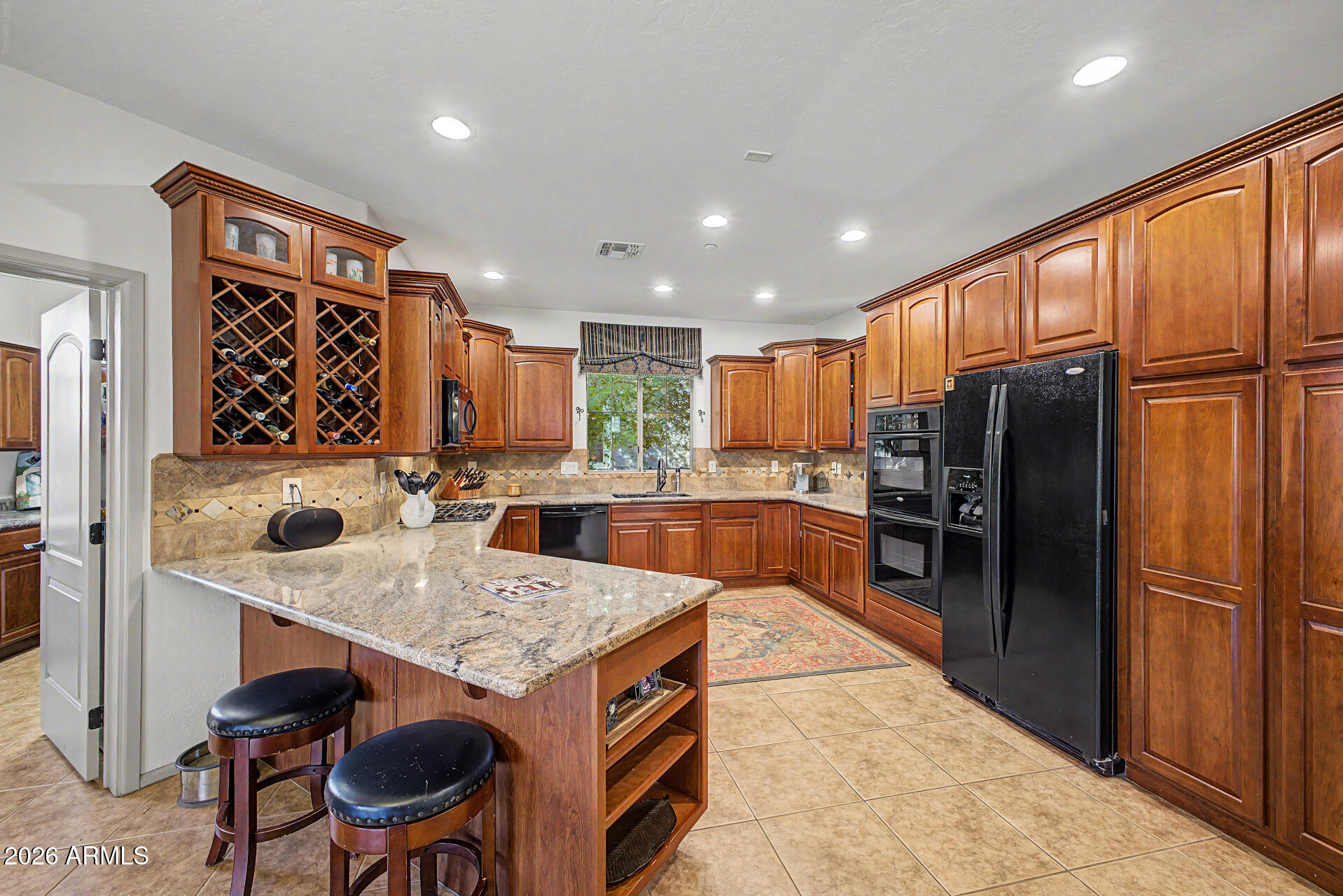 2996 East Agritopia Loop North Gilbert, AZ 85296 - Photo 13 of 73 a kitchen with stainless steel appliances granite countertop a refrigerator a oven a sink a dining table and chairs