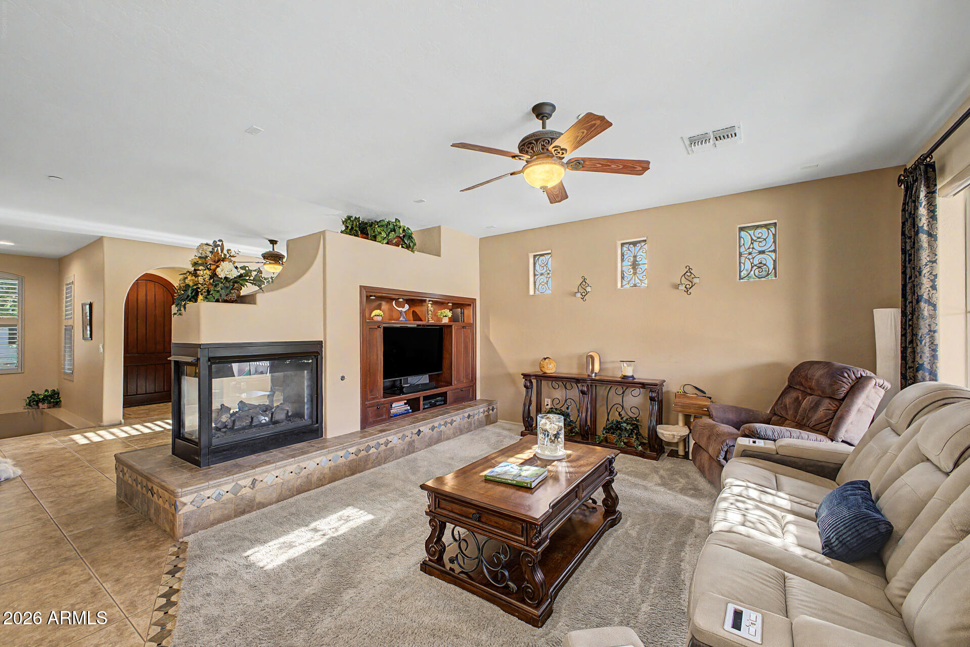 2996 East Agritopia Loop North Gilbert, AZ 85296 - Photo 6 of 73 a living room with furniture a fireplace and a flat screen tv