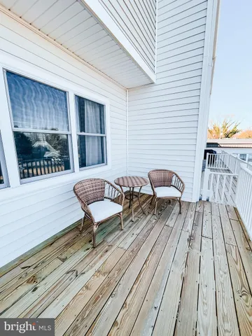 a balcony with wooden floor table and chairs