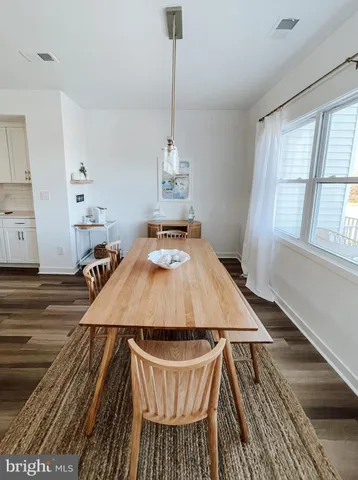 a room with wooden floor pool table chairs and windows