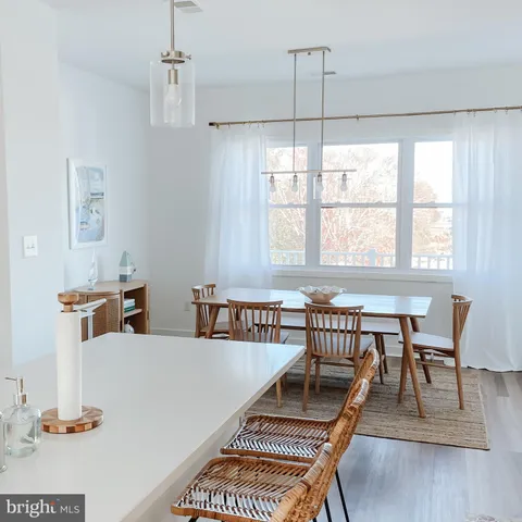 a dining room with furniture a chandelier and wooden floor