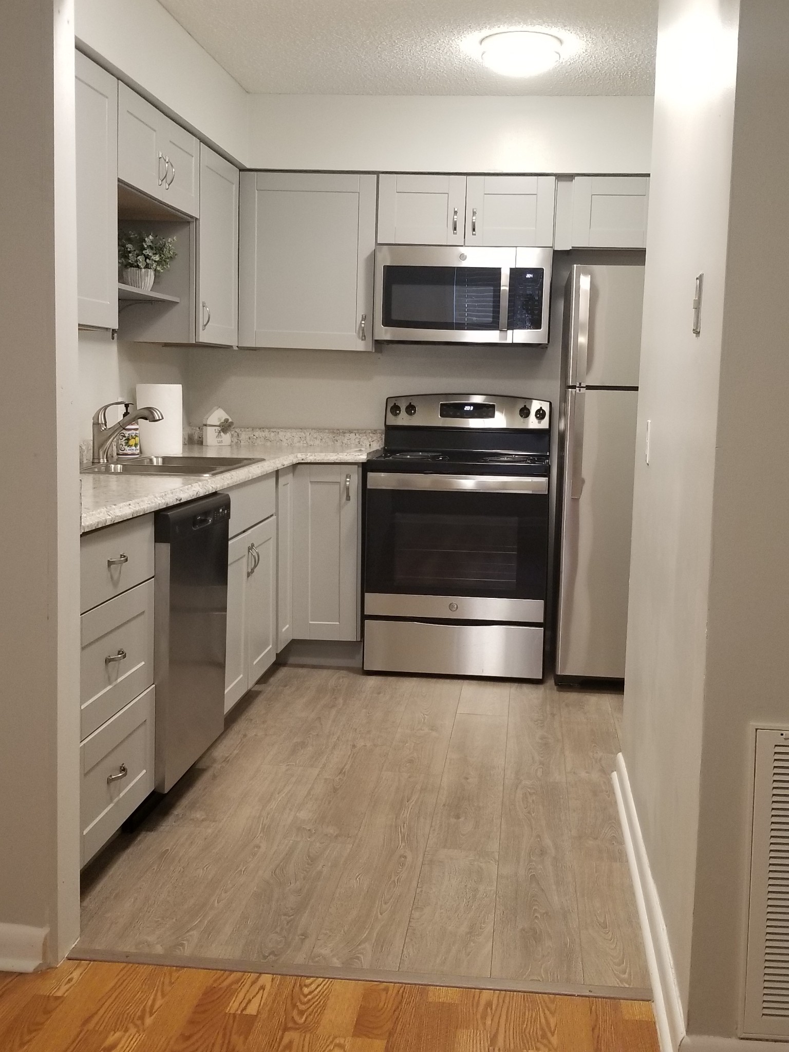 a kitchen with granite countertop a stove and a microwave