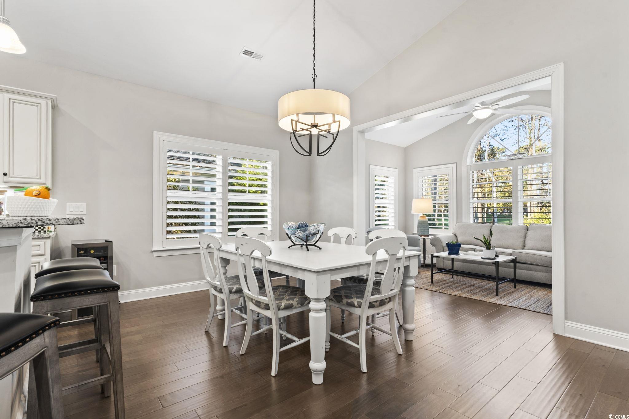 636 Elmwood Circle Murrells Inlet, SC 29576 - Photo 12 of 36 Dining area featuring lofted ceiling, dark wood finished floors, healthy amount of natural light, and a chandelier