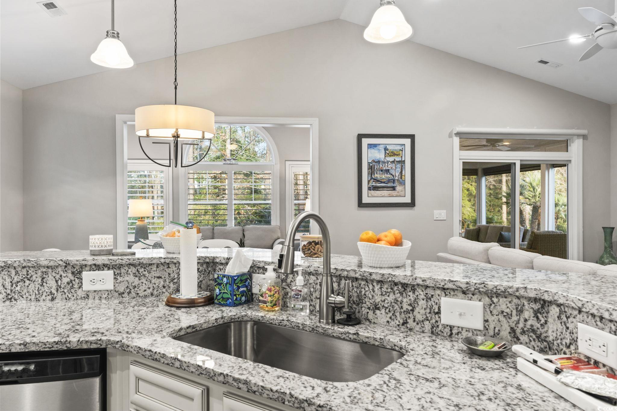 636 Elmwood Circle Murrells Inlet, SC 29576 - Photo 36 of 36 Kitchen with light stone countertops, open floor plan, stainless steel dishwasher, lofted ceiling, and healthy amount of natural light