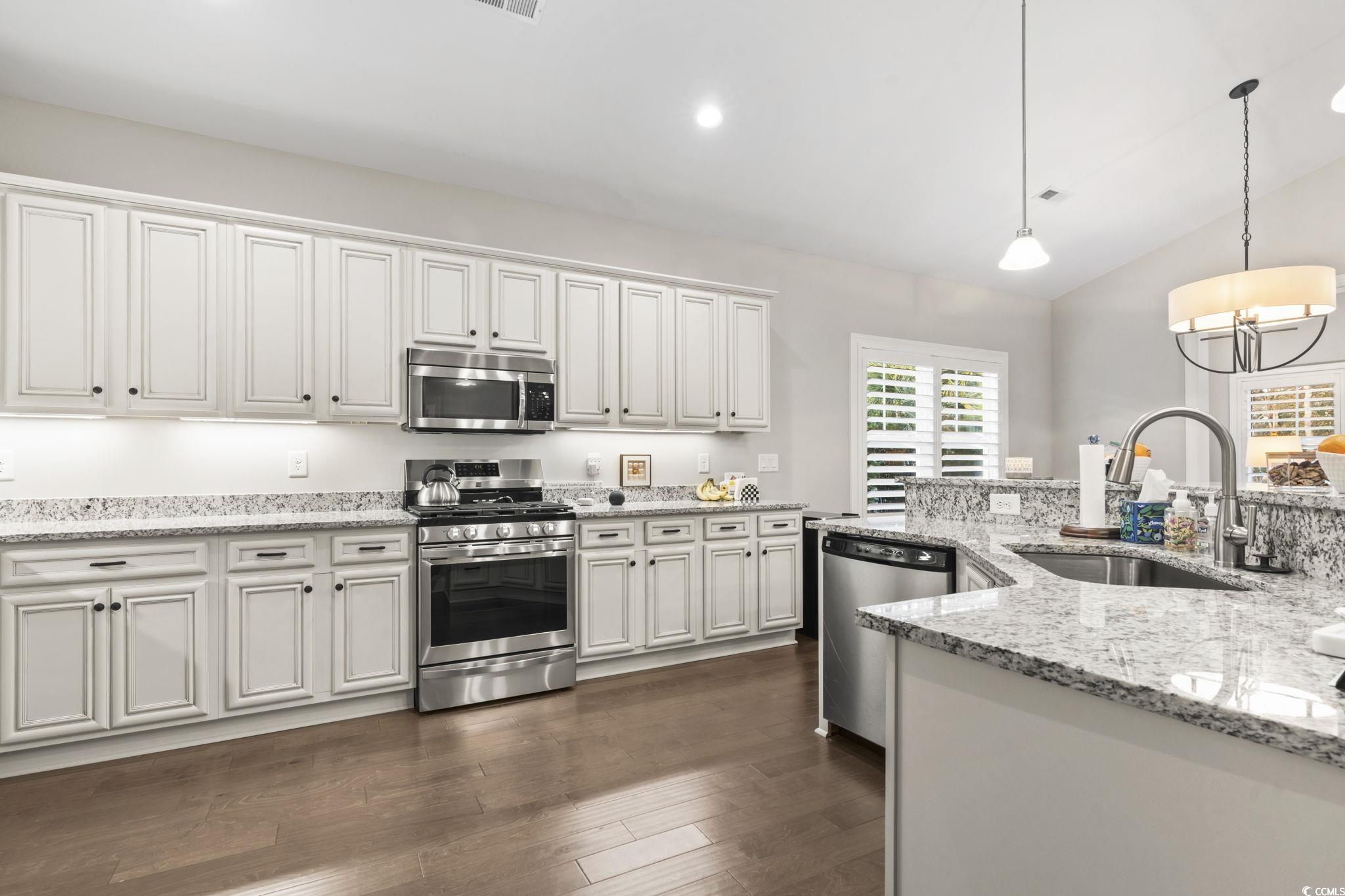 636 Elmwood Circle Murrells Inlet, SC 29576 - Photo 8 of 36 Kitchen featuring stainless steel appliances, pendant lighting, light stone counters, lofted ceiling, and dark wood-style flooring