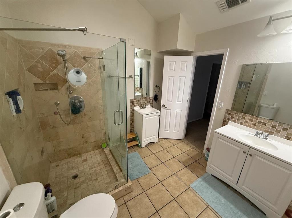 6505 Mc Cormick Ranch Court Plano, TX 75023 - Photo 15 of 21 Glass-enclosed shower with stone tile surround and built-in niche