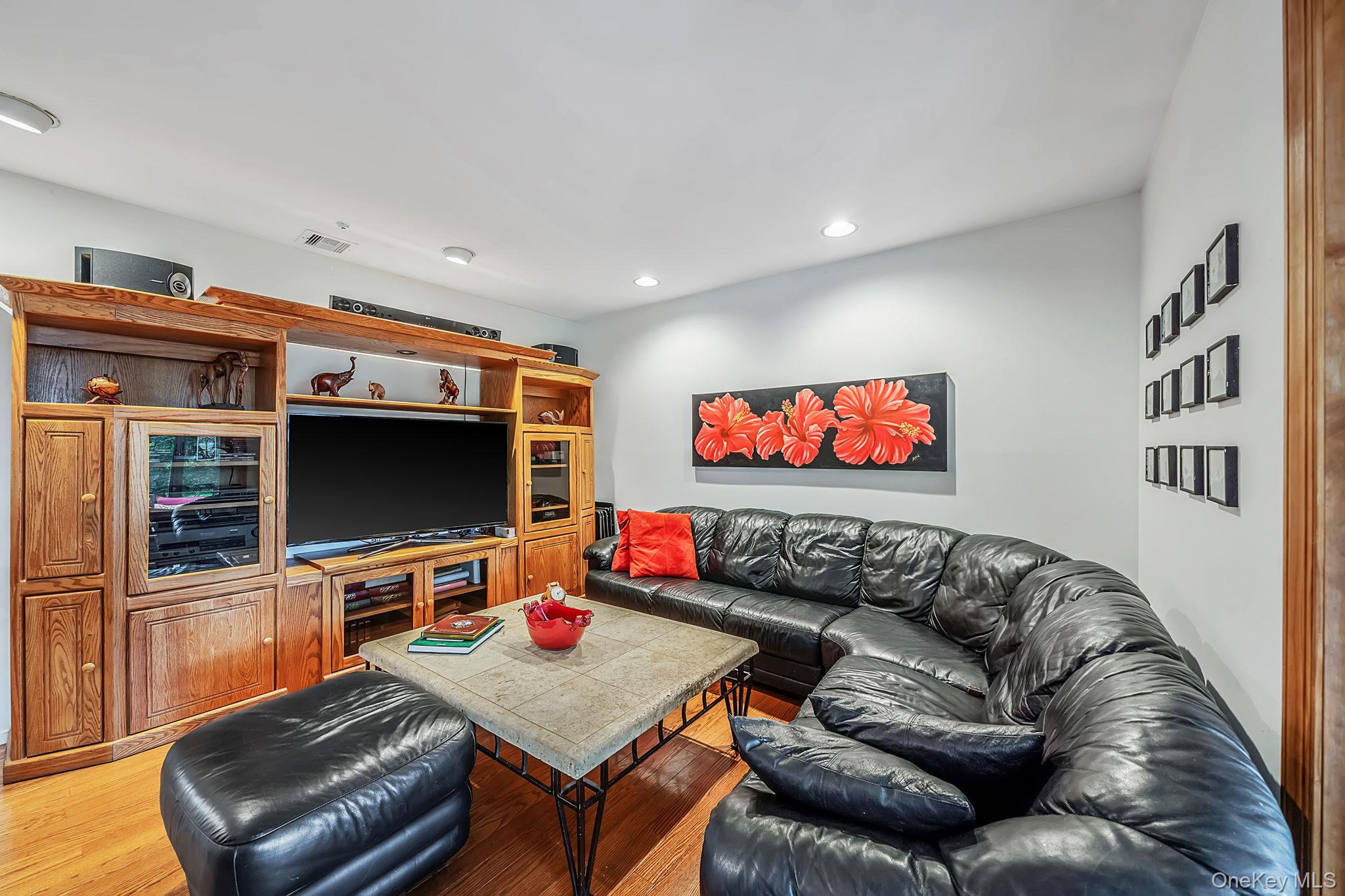 96 Fulton Boulevard Commack, NY 11725 - Photo 26 of 41 a living room with furniture and a flat screen tv