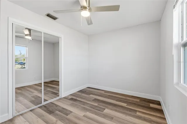 an empty room with a ceiling fan and window