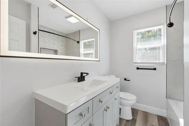 a bathroom with a sink a toilet and a window