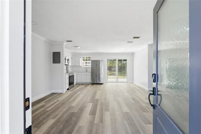 a view of a room with wooden floor and a bathroom
