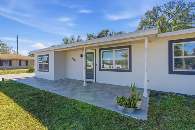 a view of a house with a backyard and a porch