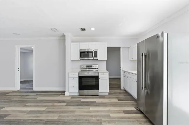 a view of a kitchen with a sink stove refrigerator and cabinets