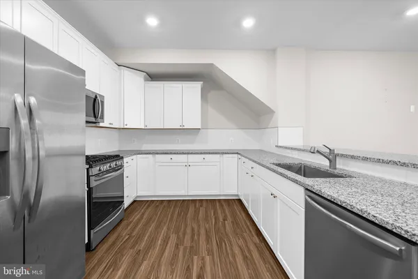 a kitchen with a sink and wooden floor