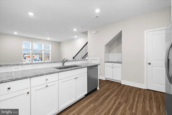 a kitchen with granite countertop a sink and refrigerator