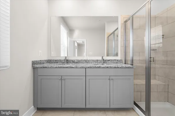 a bathroom with a granite countertop sink a toilet and shower
