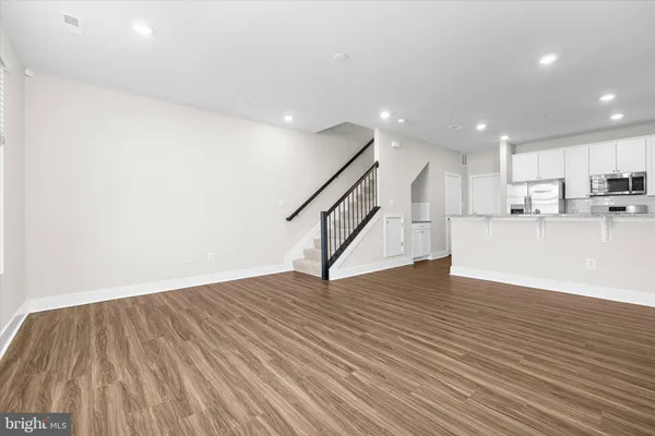 a view of a kitchen with wooden floor and stairs