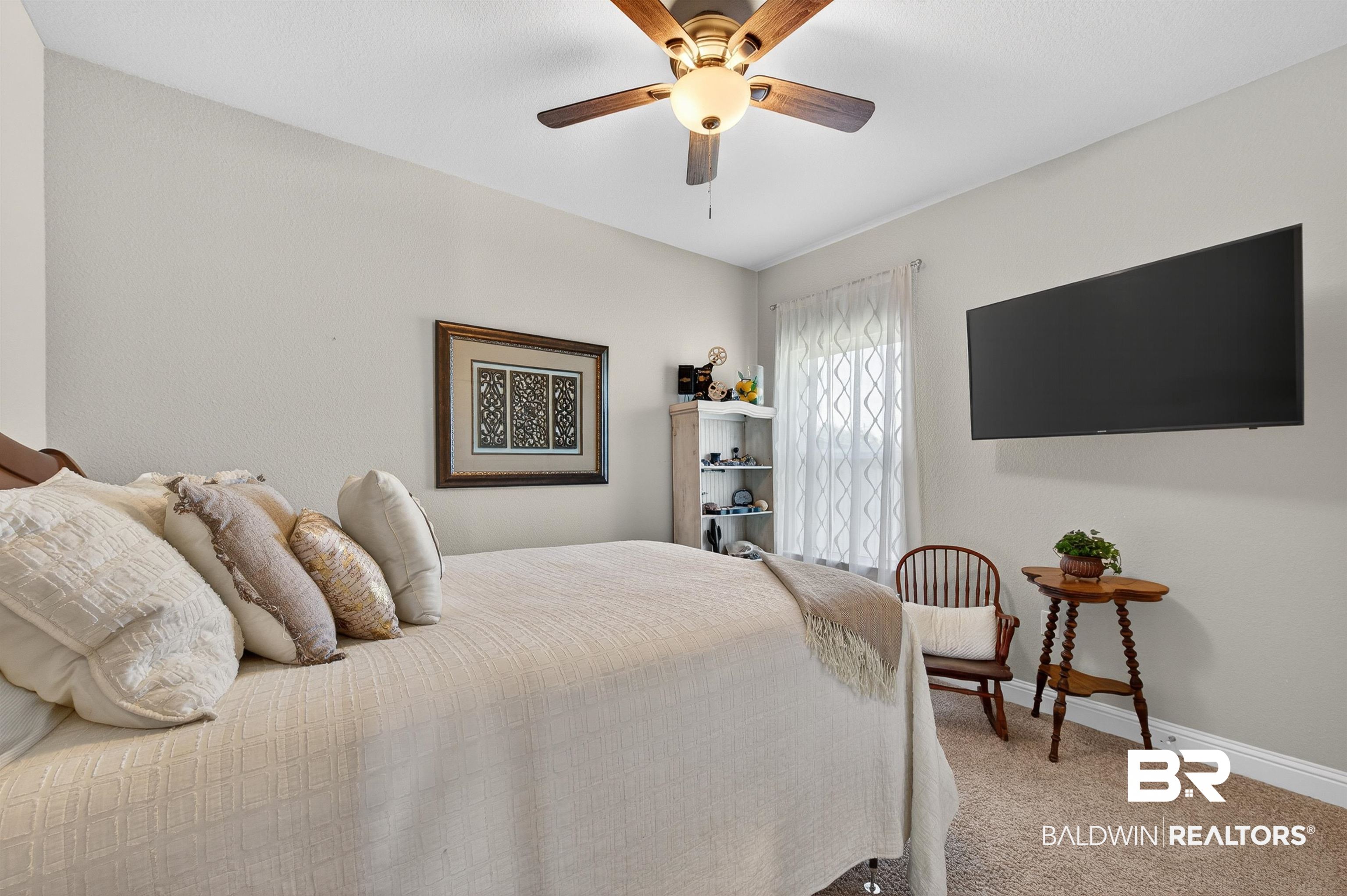 8735 Bronze Lane Foley, AL 36535 - Photo 30 of 58 Comfortable bedroom featuring a ceiling fan with integrated lighting, wall-mounted television, and neutral-toned carpeting