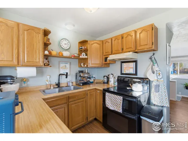a kitchen with stainless steel appliances granite countertop a sink stove refrigerator and cabinets
