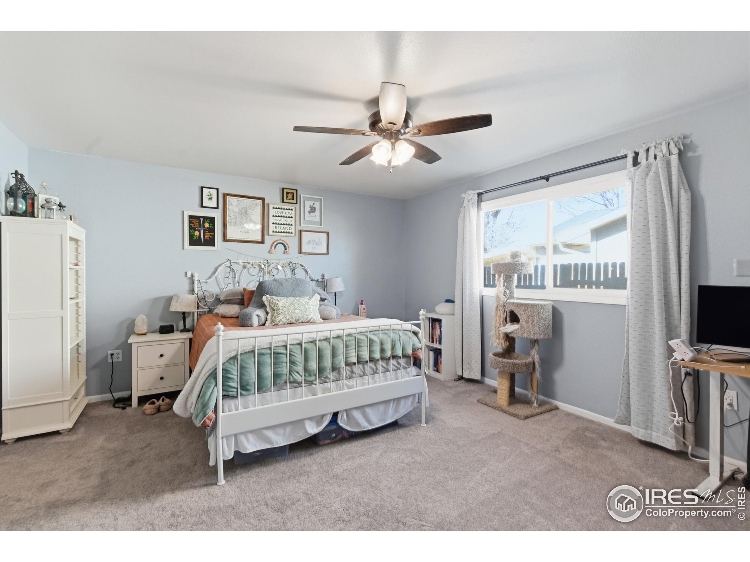 7905 3rd Street Wellington, CO 80549 - Photo 6 of 25 a bedroom with a bed and a flat tv screen on the dresser