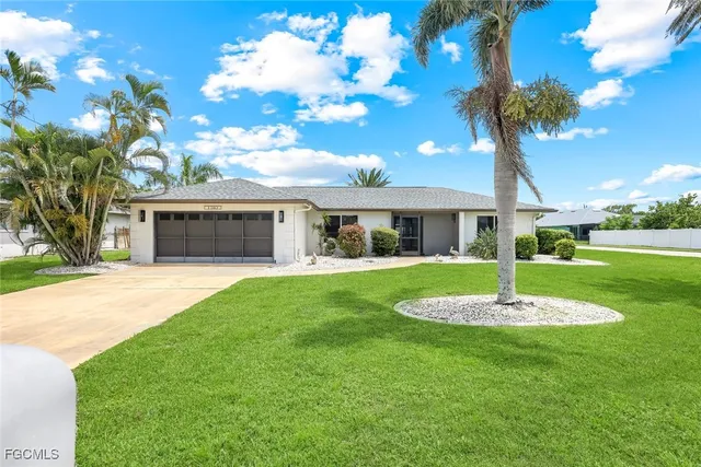 a front view of a house with a garden and trees