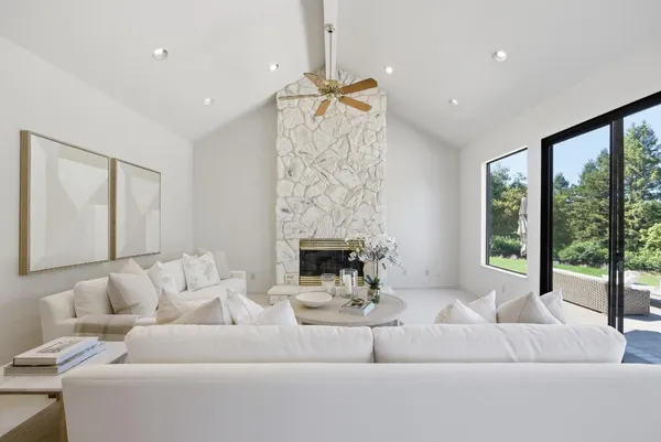 a view of a patio with table and chairs potted plants and floor to ceiling window