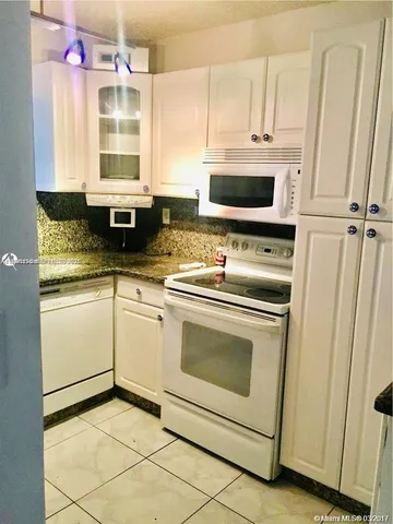 a kitchen with a stove a sink and a microwave