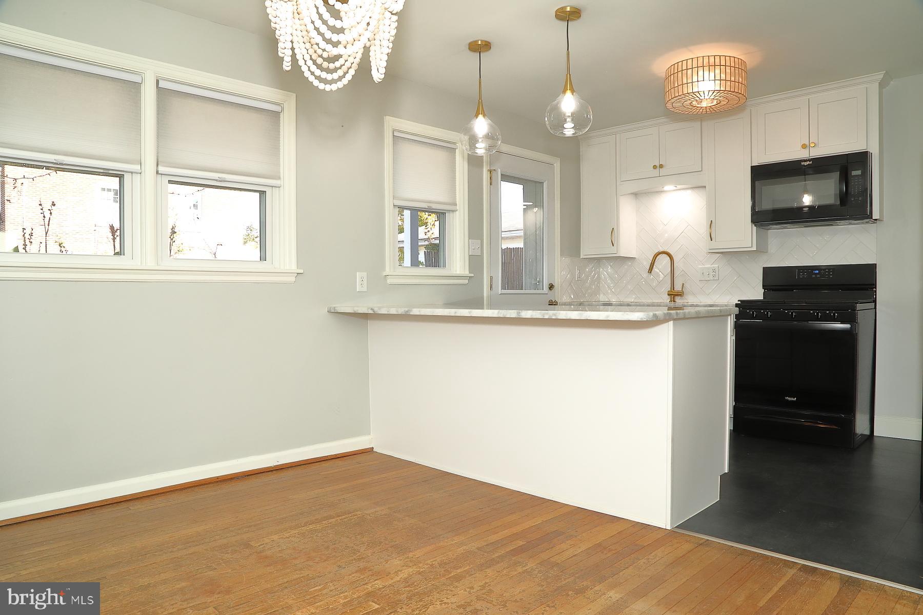 303 Euclid Avenue Lancaster, PA 17603 - Photo 12 of 24 a kitchen with granite countertop a stove a sink and a wooden floor
