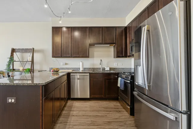 a kitchen with stainless steel appliances granite countertop a refrigerator and a stove