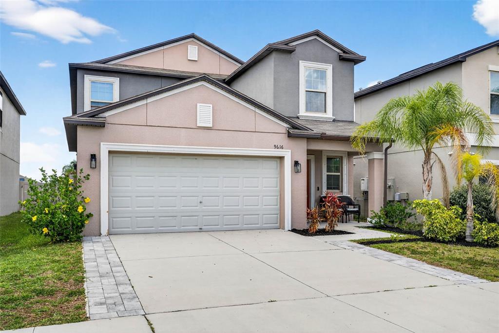 a view of a house with a yard and potted plants