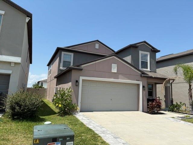 a front view of a house with a yard and garage