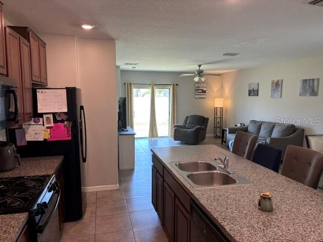 9616 Lemon Drop Loop Sun City Center, FL 33573 - Photo 12 of 48 a kitchen with a stove a sink and a refrigerator