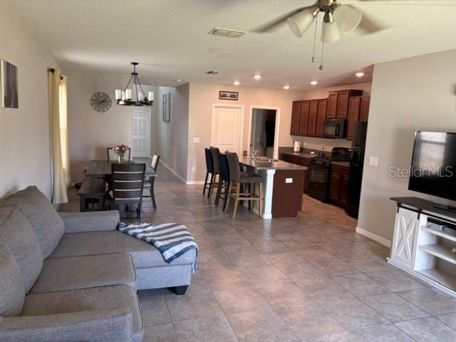 9616 Lemon Drop Loop Sun City Center, FL 33573 - Photo 16 of 48 a living room with furniture kitchen view and a refrigerator
