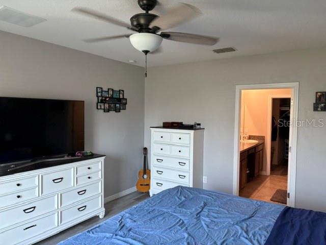9616 Lemon Drop Loop Sun City Center, FL 33573 - Photo 31 of 48 a bedroom with a bed and wooden floor