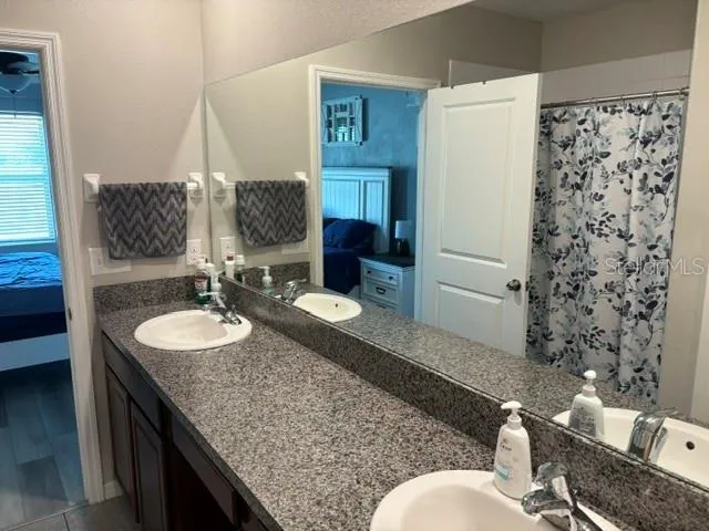 a close view of walk in closet with clothes and shoes