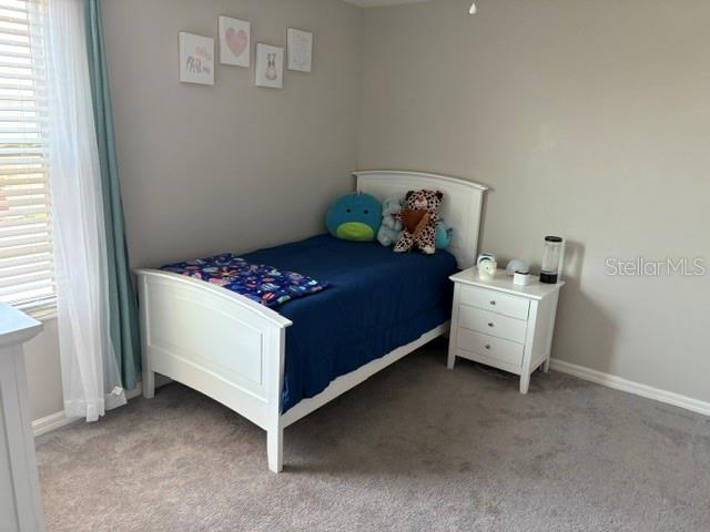 9616 Lemon Drop Loop Sun City Center, FL 33573 - Photo 35 of 48 a bedroom with a bed and a window